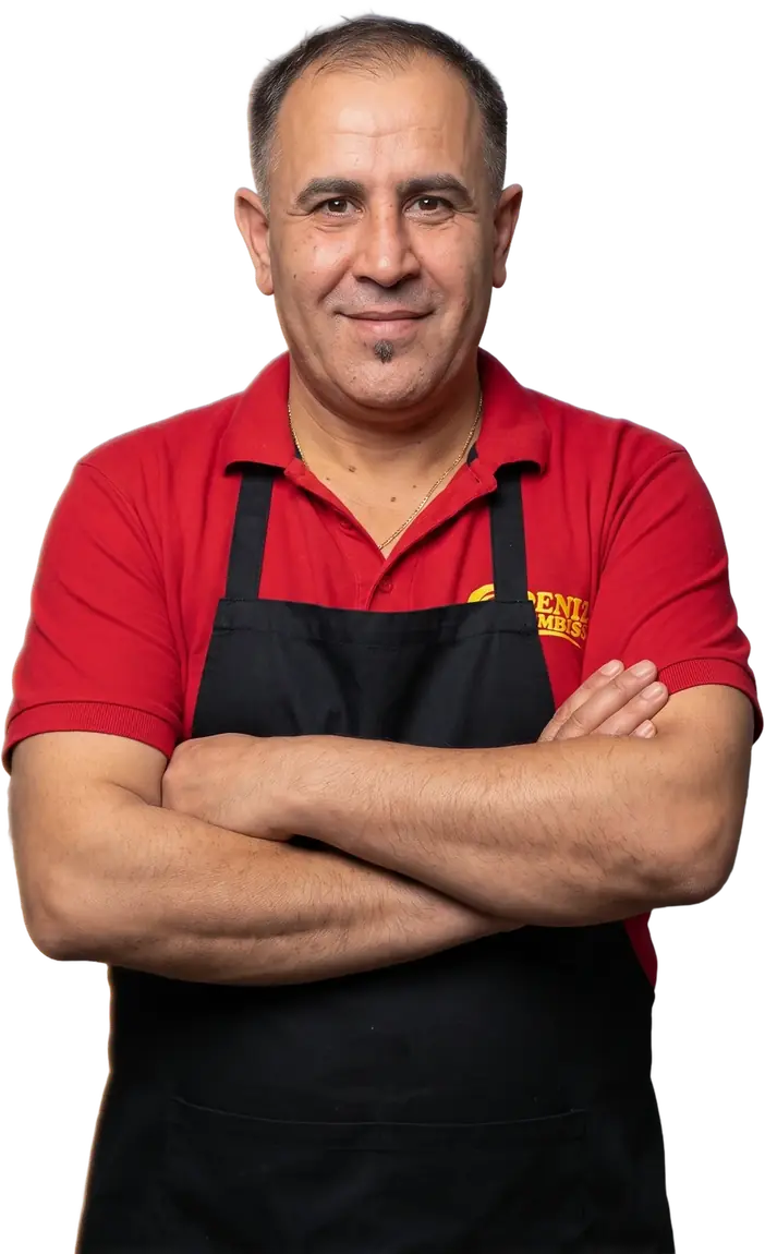 Hasan von Deniz Imbiss, mit Schürze und verschränkten Armen